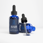Methylene Blue Drops, one bottle upright and one on its side with the dropper alongside